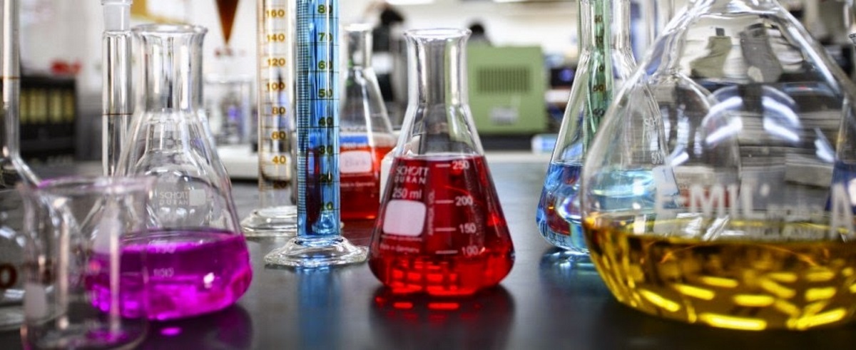 Химические колбы с разноцветными реактивами на столе